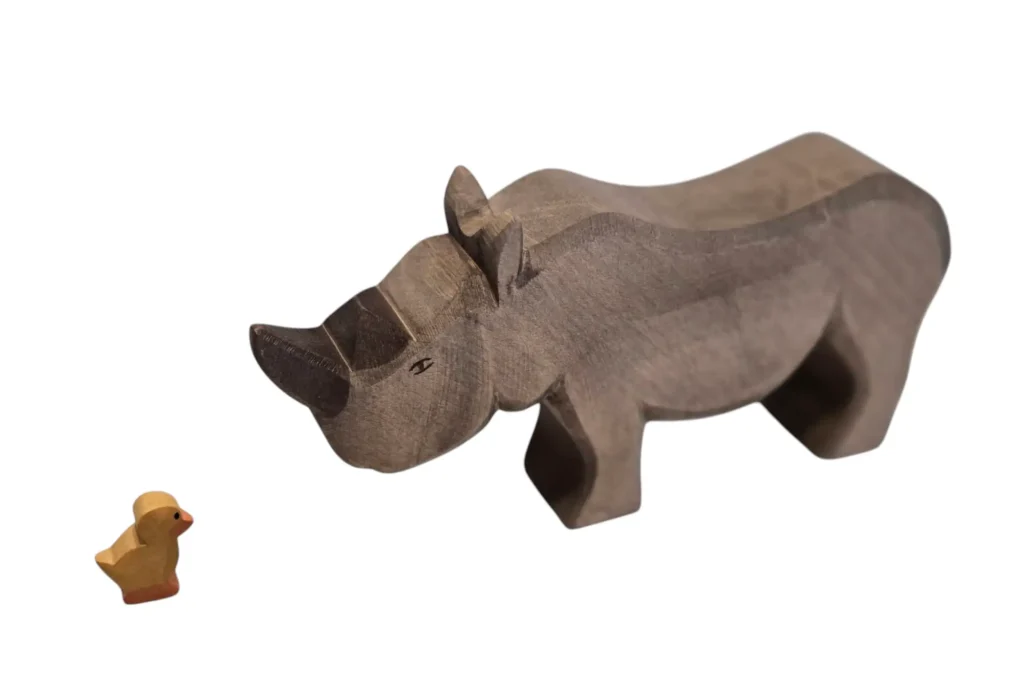 kleines Kücken, riesiges Nashorn stehen sich gegenüber
